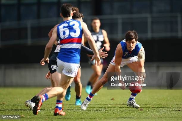 Angus Monfries of Footscray handballs during the round 13 VFL match between the Northern Blues and the Footscray Bulldogs at Ikon Park on June 30,...