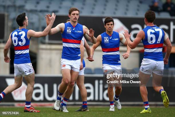 Fletcher Roberts of Footscray celebrates with his teammates after kicking a goal during the round 13 VFL match between the Northern Blues and the...