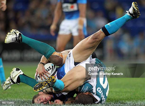 Ashley Harrison of the Titans is tackled during the round eight NRL match between the Gold Coast Titans and the Penrith Panthers at Skilled Park on...