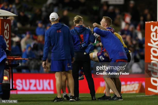 Slade Griffin of the Knights is carried off the ground injured during the round 16 NRL match between the Newcastle Knights and the Canterbury...