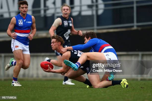 Joel Naylor of the Blues is tackled by Lewis Young of Footscray during the round 13 VFL match between the Northern Blues and the Footscray Bulldogs...