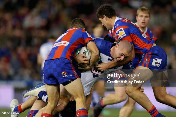 David Klemmer of the Bulldogs is tackled by the Knights defence during the round 16 NRL match between the Newcastle Knights and the Canterbury...