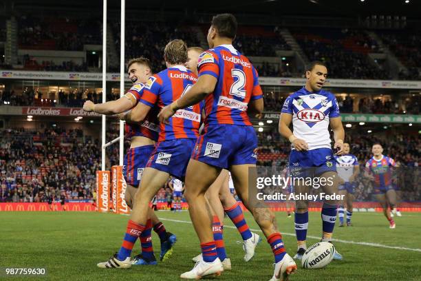 Connor Watson of the Knights celebrates a try with team mates during the round 16 NRL match between the Newcastle Knights and the Canterbury Bulldogs...