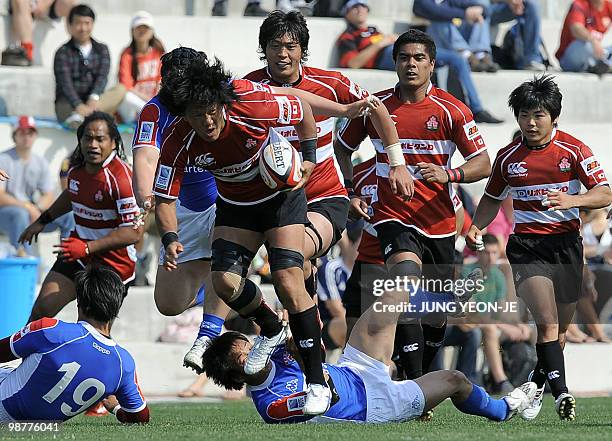 Japan's Takashi Kikutani evades a tackle from South Korean players during their match of the Asian Five Nations and Rugby World Cup Asian Qualifiers...