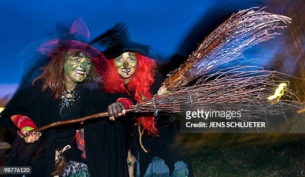 Two Walpurgisnacht enthousiasts dressed as witches dance on late April 30, 2010 at the Brocken mountain near Schierke, eastern Germany. In the...