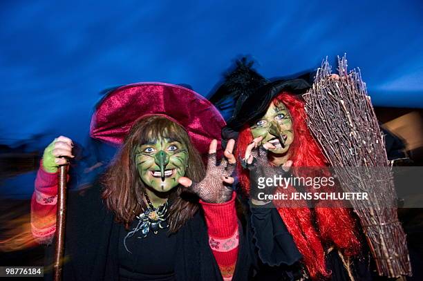 Two Walpurgisnacht enthousiasts dressed as witches dance on late April 30, 2010 at the Brocken mountain near Schierke, eastern Germany. In the...