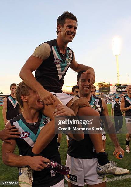 Steven Salopek gets chaired off by Brett Ebert and Troy Chaplin of the Power during the round six AFL match between the Adelaide Crows and the Port...