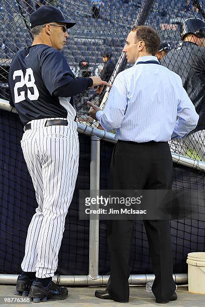 Manager Joe Girardi of the New York Yankees talks with Yankee general manager Brian Cashman during batting practice prior to the game against the...