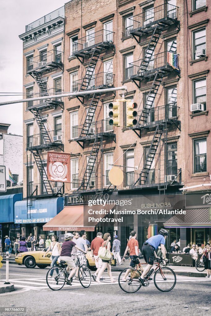 Manhattan, Chelsea, 8th Avenue, people and bicycles crossing the street