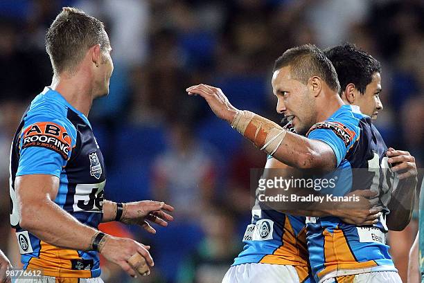 Scott Prince of the Titans celebrates with team mates after a try by team mate Ashley Harrison during the round eight NRL match between the Gold...
