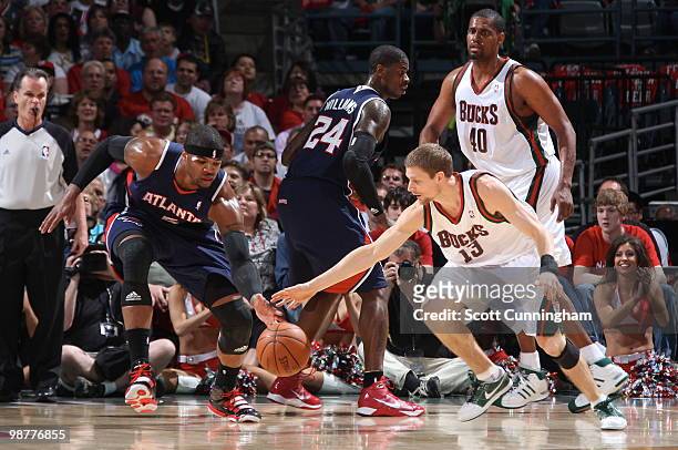 Josh Smith of the Atlanta Hawks battles for a loose ball against Luke Ridnour of the Milwaukee Bucks in Game Six of the Eastern Conference...