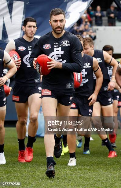 Kade Simpson of the Blues runs through the banner before his 300th match during the 2018 AFL round 15 match between the Carlton Blues and the Port...