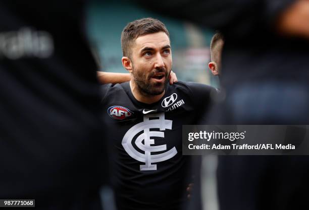 Kade Simpson of the Blues listens in before his 300th match to captain Marc Murphy of the Blues during the 2018 AFL round 15 match between the...