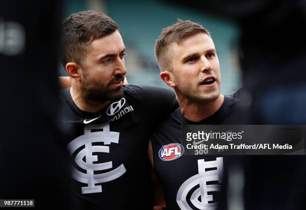 Kade Simpson of the Blues listens in before his 300th match to captain Marc Murphy of the Blues during the 2018 AFL round 15 match between the...