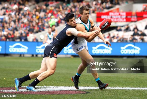 Jack Trengove of the Power is tackled by Matthew Kennedy of the Blues during the 2018 AFL round 15 match between the Carlton Blues and the Port...