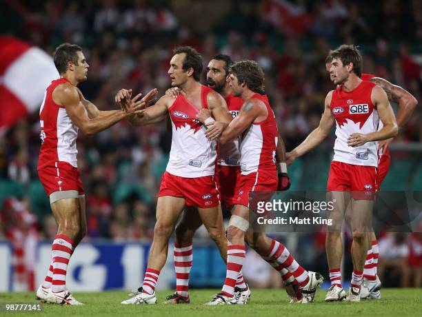 Daniel Bradshaw of the Swans celebrates with team mates after scoring a goal during the round six AFL match between the Sydney Swans and the Brisbane...