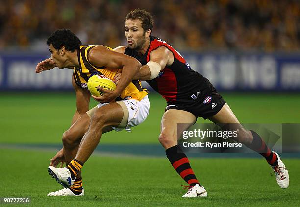 Cyril Rioli of the Hawks is tackled by Mark McVeigh of the Bombers during the round six AFL match between the Essendon Bombers and the Hawthorn Hawks...