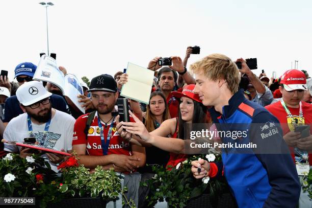 Brendon Hartley of New Zealand and Scuderia Toro Rosso arrives at the circuit and poses for a photo with fans before final practice for the Formula...