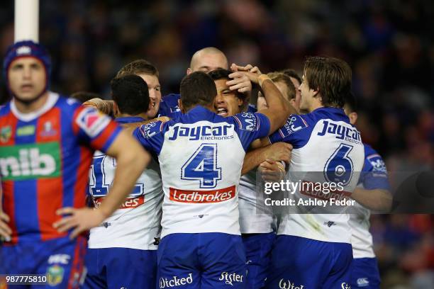 Fa'amanu Brown of the Bulldogs celebrates his try with team mates during the round 16 NRL match between the Newcastle Knights and the Canterbury...