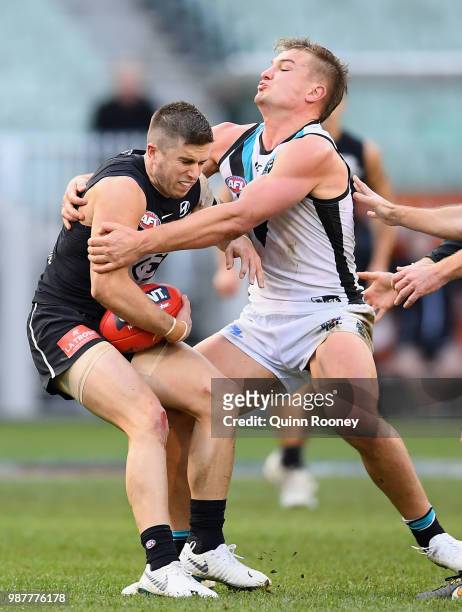 Marc Murphy of the Blues is tackled by Ollie Wines of the Power during the round 15 AFL match between the Carlton Blues and the Port Adelaide Power...