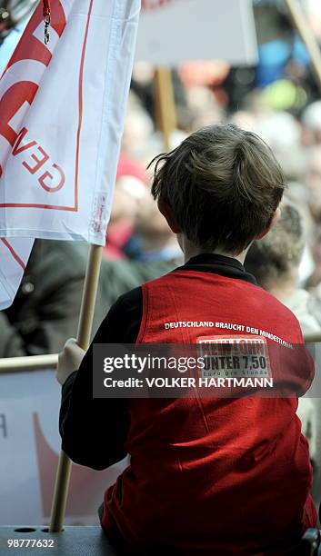 Child, wearing a t-shirt reading "Germany needs the minimum wage. No wage under 7.50 Euro per hour" sits during a May Day demonstration in Essen,...