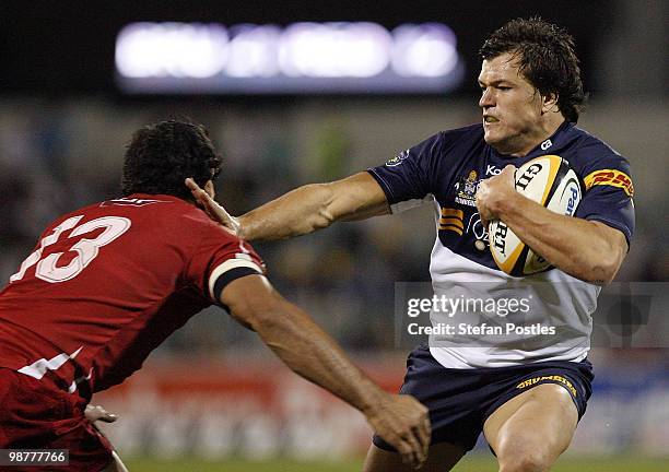 Adam Ashley-Cooper of the Brumbies fends off a tackle by Will Chambers of the Reds during the round 12 Super 14 match between the Brumbies and the...