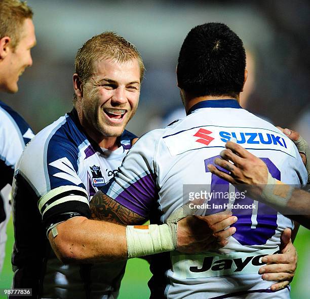 Todd Lowry of the Storm congratulates teammate Jeff Lima after he scored a try during the round eight NRL match between the North Queensland Cowboys...