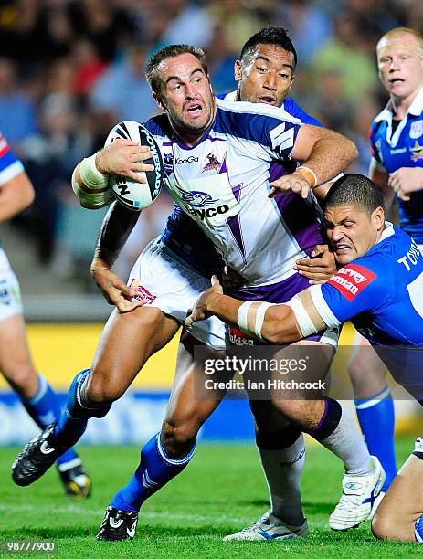 Ryan Tandy of the Storm looks to get past Willie Mason and Manase Manoukafoa of the Cowboys during the round eight NRL match between the North...