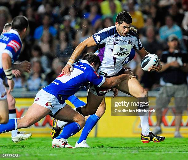 Greg Inglis of the Storm breaks through the Cowboys defence during the round eight NRL match between the North Queensland Cowboys and the Melbourne...