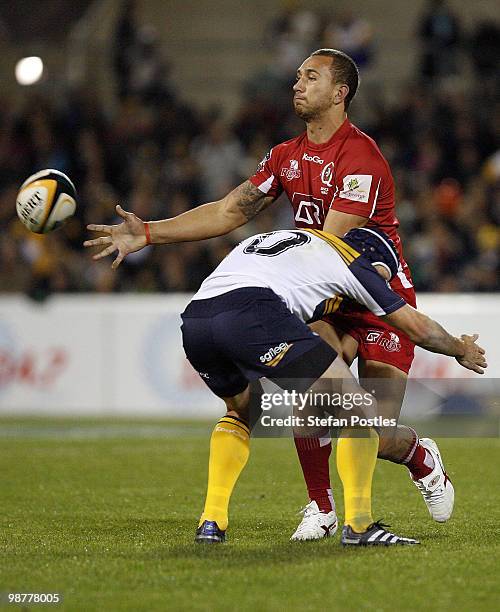 Quade Cooper of the Reds is tackled by Matt Giteau during the round 12 Super 14 match between the Brumbies and the Reds at Canberra Stadium on May 1,...