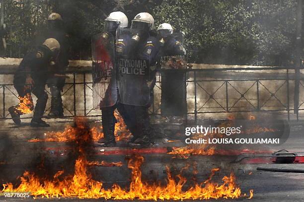 Police escapes molotov cocktail flames outside the greek Parliament during a massive Mayday demonstration to protest the austerity measures on May 1,...