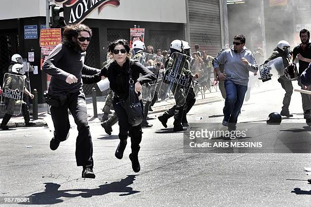 Demonstrators run away from riot police during a May Day protest in Athens on May 1, 2010. Greek police fired tear gas on youths as marchers swarmed...