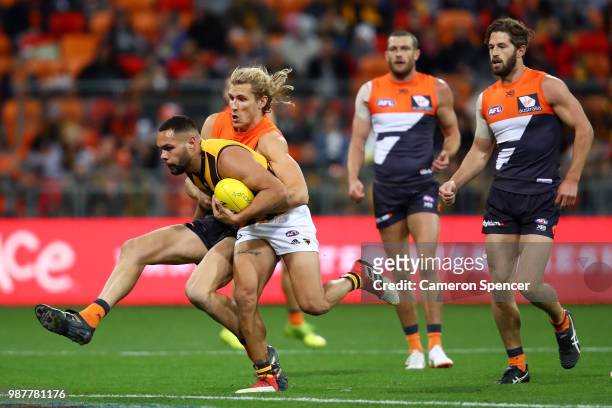 Jarman Impey of the Hawks is tackled during the round 15 AFL match between the Greater Western Sydney Giants and the Hawthorn Hawks at Spotless...