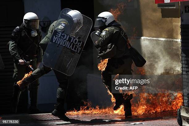 Greek riot policeman runs away from a fire after a group set fire with a molotov cocktail, during a May day protest in Athens on May 1, 2010. Greek...