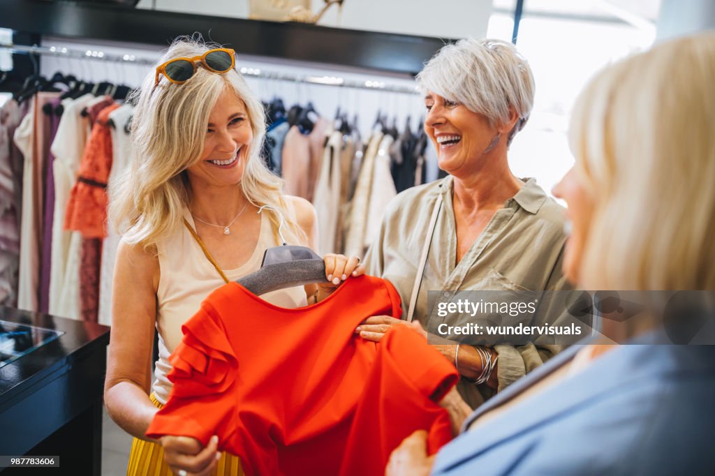 Fashionable mature women shopping for clothes in fashion boutique
