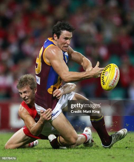 Andrew Raines of the Lions is tackled by Keiren Jack of the Swans during the round six AFL match between the Sydney Swans and the Brisbane Lions at...