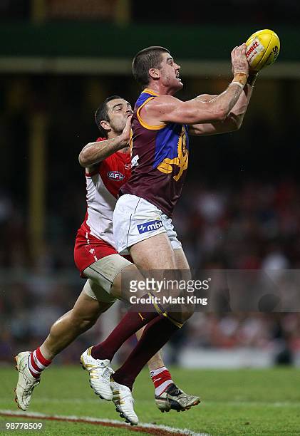 Jonathan Brown of the Lions marks in front of Heath Grundy of the Swans during the round six AFL match between the Sydney Swans and the Brisbane...
