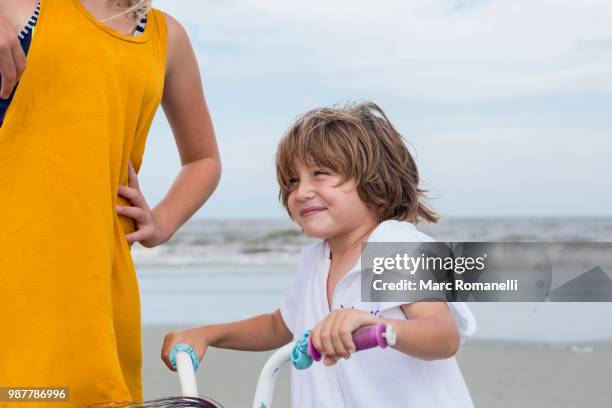 sister teaching her brother to bike - marc romanelli stock pictures, royalty-free photos & images