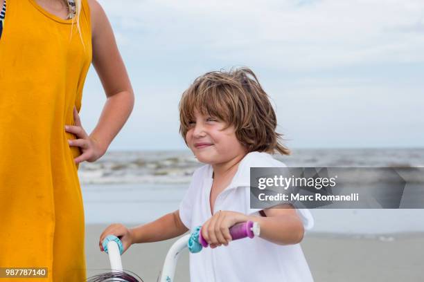 sister teaching her brother to bike - marc romanelli stock pictures, royalty-free photos & images