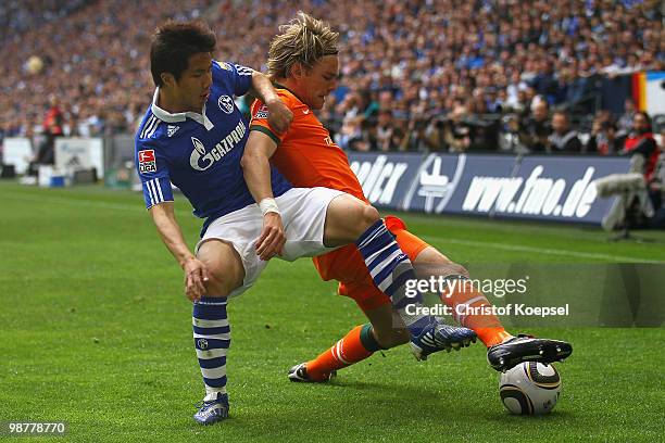 Hao Junmin of Schalke challenges Clemens Fritz of Bremen during the Bundesliga match between FC Schalke 04 and SV Werder Bremen at Veltins Arena on...