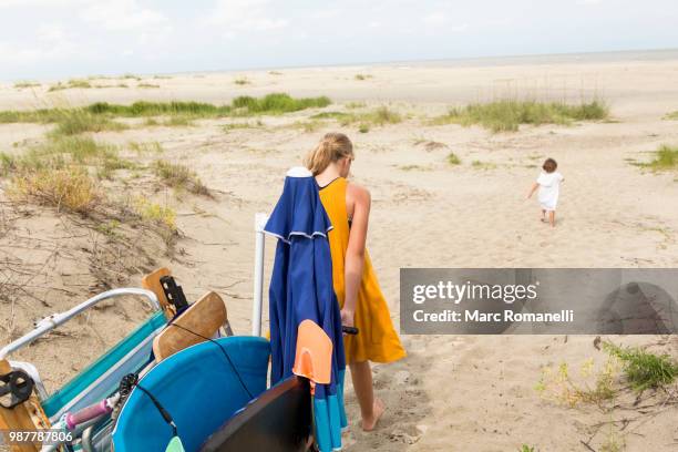 girl pulling beach cart - marc romanelli stock pictures, royalty-free photos & images