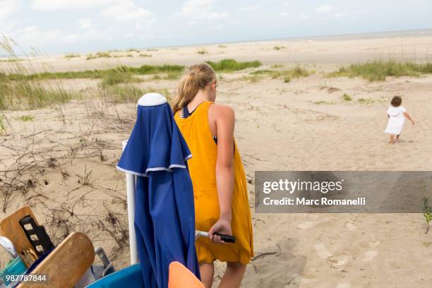 girl pulling beach cart - marc romanelli stock pictures, royalty-free photos & images