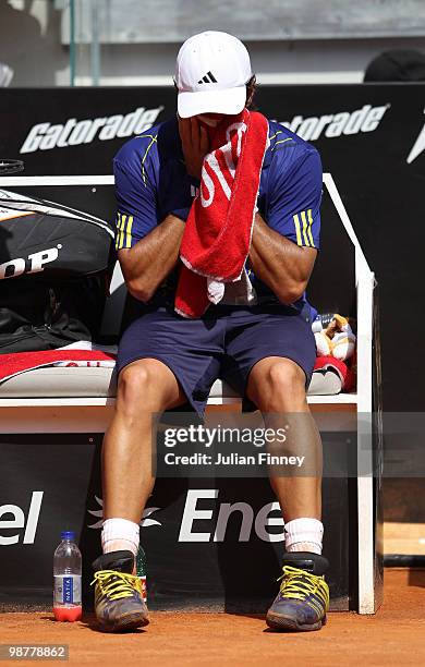 Fernando Verdasco of Spain struggles in his match against David Ferrer of Spain plays a backhand in his match against during day seven of the ATP...