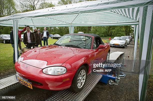 Visitors look at a cabrio in Maarssen on May , 2010. About 740 Mazda MX-5 cabrios gathered at the Maarsseveense Plassen to celebrate the 20th...