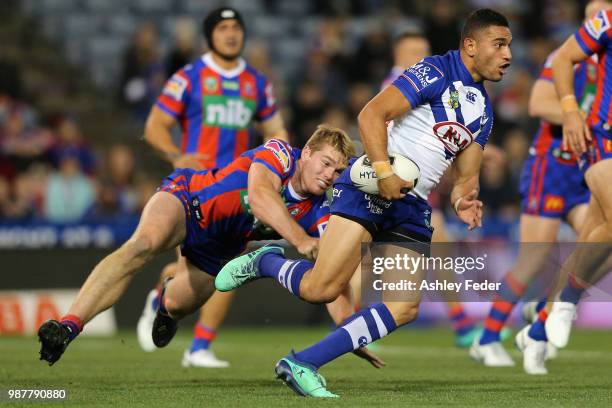 Marcelo Montoya of the Bulldogs is tackled by the Knights defence during the round 16 NRL match between the Newcastle Knights and the Canterbury...