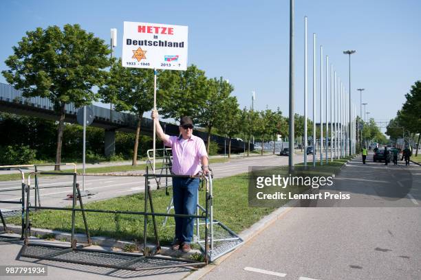 Supporter of the right-wing Alternative for Germany political party displays a banner outside the venue of the AfD federal congress on June 30, 2018...