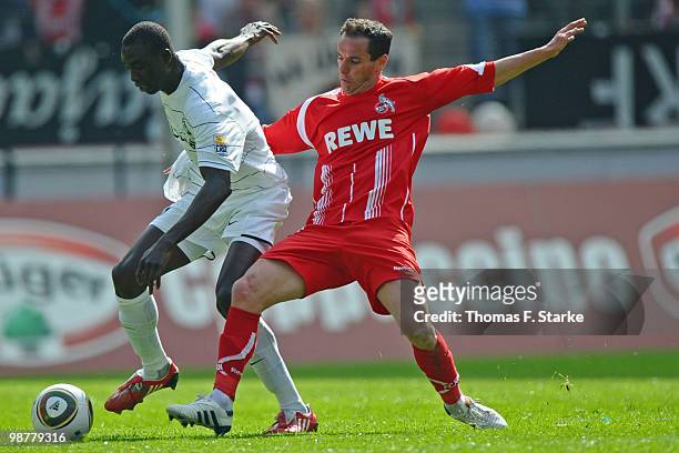 Petit of Cologne tackles Papiss Demba Cisse of Freiburg during the Bundesliga match between 1. FC Koeln and SC Freiburg at RheinEnergieStadion on May...