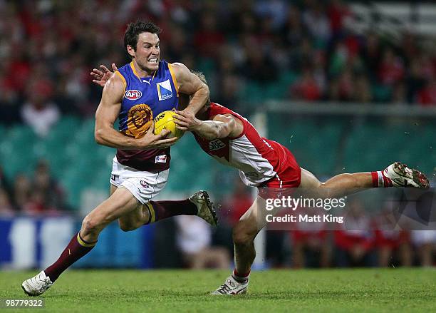 Andrew Raines of the Lions is tackled by Keiren Jack of the Swans during the round six AFL match between the Sydney Swans and the Brisbane Lions at...