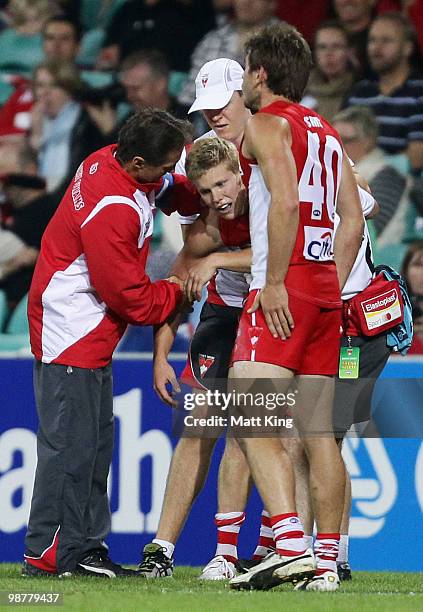 Daniel Hannebery of the Swans is attended to after dislocating his shoulder during the round six AFL match between the Sydney Swans and the Brisbane...