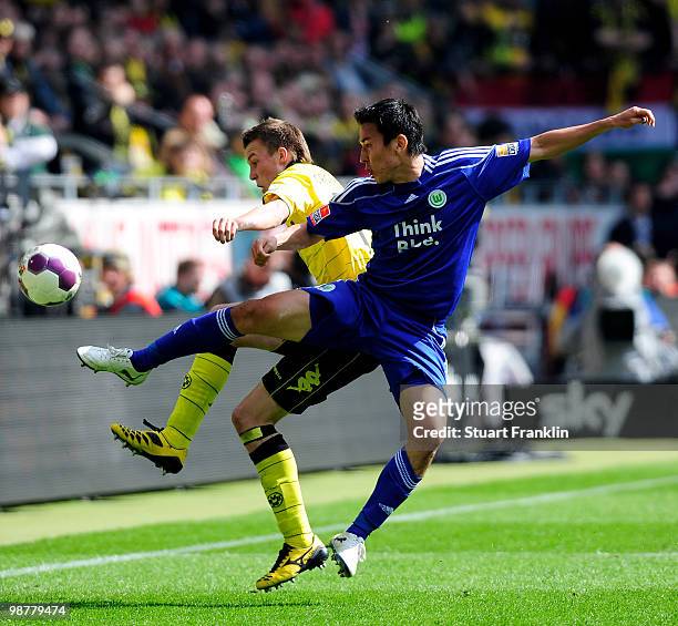 Kevin Grosskreutz of Dortmund is challenged by Makoto Hasebe of Wolfsburg during the Bundesliga match between Borussia Dortmund and VfL Wolfsburg at...